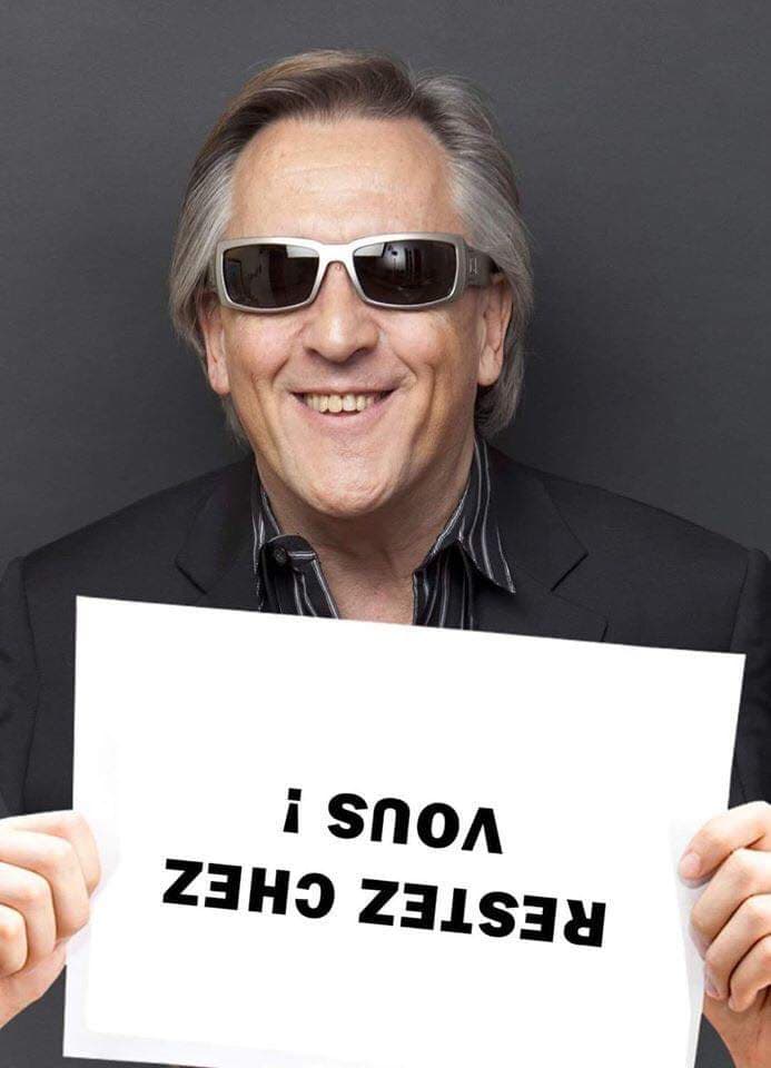 Blague confinement   gilert montagnier avec ne pencarte tenu à l'envers